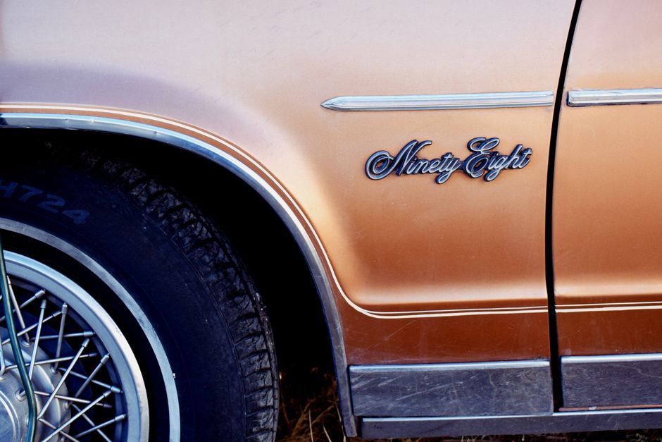 A classic 1970s Pontiac Trans Am representing the Smokey and the Bandit era speeding down a highway