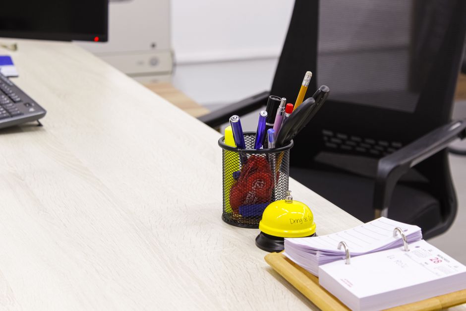 A neat desk setup with a laptop, calculator, and notepad representing freelance business finances