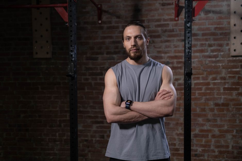 A trainer standing next to a gym in Pokemon Go, showing their username above their avatar