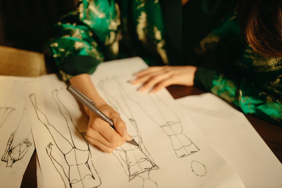 A close-up of a designer sketching minimalist typography logos on a clean wooden desk with natural lighting