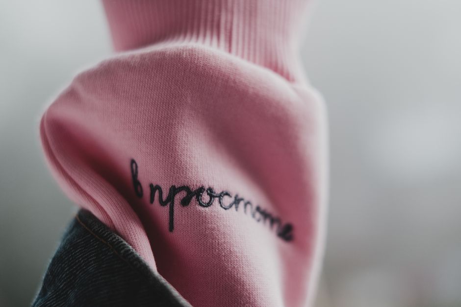 A close-up of embroidered initials on a crisp white collar with soft morning lighting