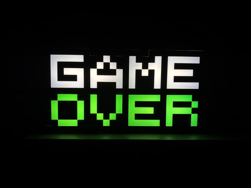 A neon-lit gaming room setup showing a high-tech computer monitor and gaming peripherals