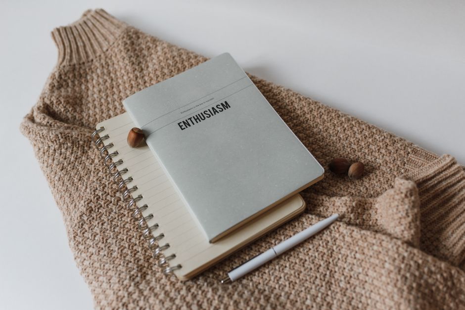 A notebook with handwritten creative usernames next to a camera and creator desk lighting