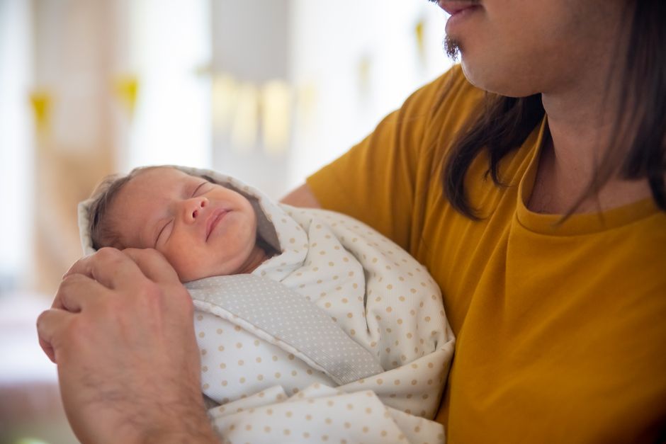A proud father holding his newborn baby boy, symbolizing the passing down of a family legacy and inheritance