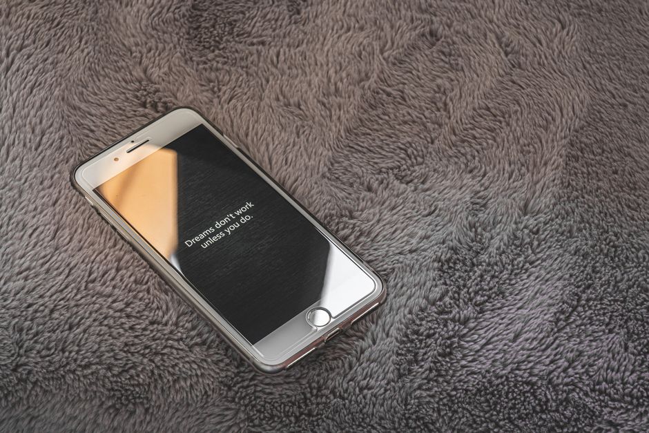 A smartphone resting on a dark neon desk displaying an edgy dark-mode profile screen