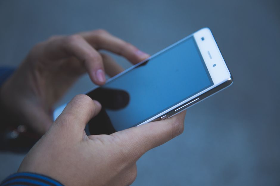A smartphone user scanning a personalized TikTok QR code displayed on another screen