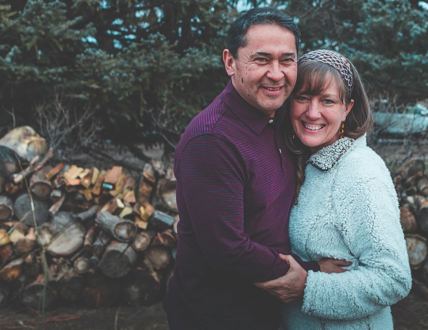 A smiling couple filming a creative TikTok video using a smartphone and ring light setup