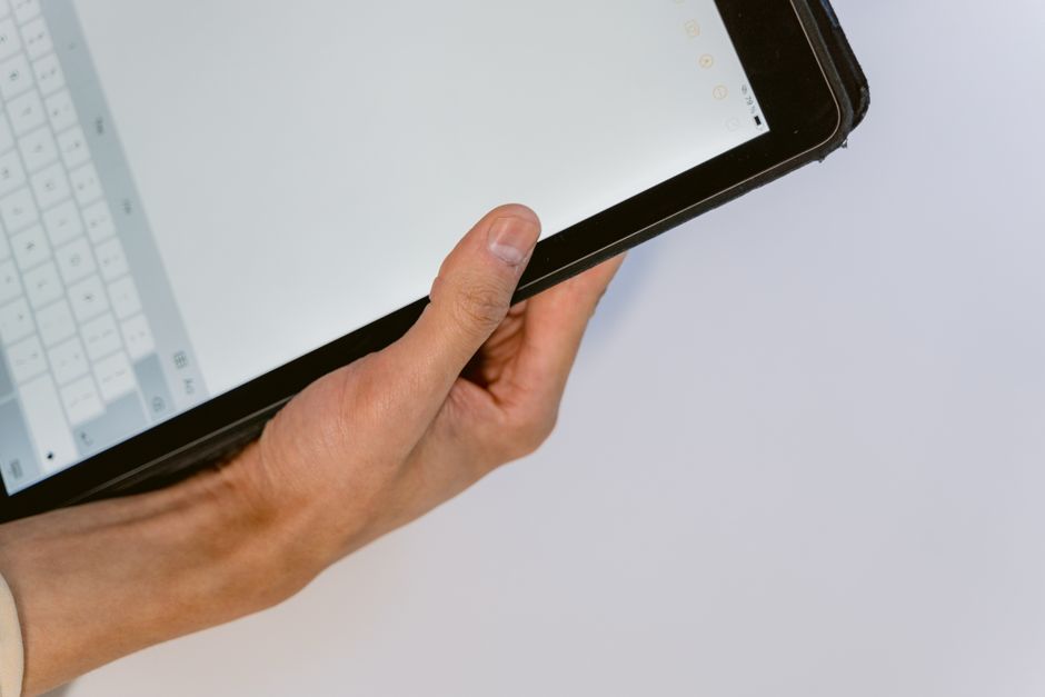 A user holding a smartphone showing the TikTok login screen with an account recovery prompt