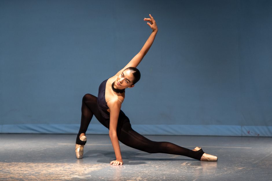A young dancer smiling while holding a smartphone and checking username availability on social media