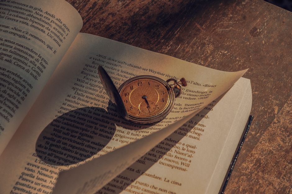 An antique open dictionary resting on a rainy desk with moody atmospheric lighting