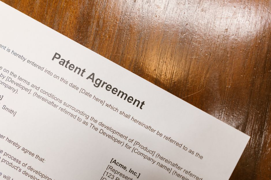 An intellectual property document sitting next to a digital tablet displaying TikTok's online trademark reporting portal