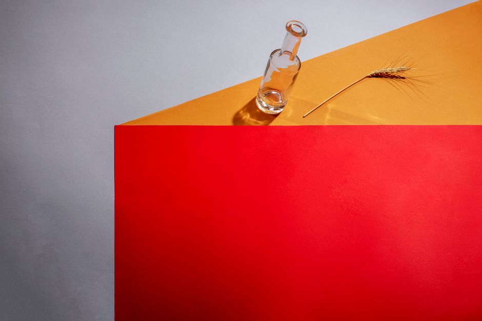 Bodegón minimalista con cámara fotográfica antigua, café y cuaderno de notas sobre fondo neutro