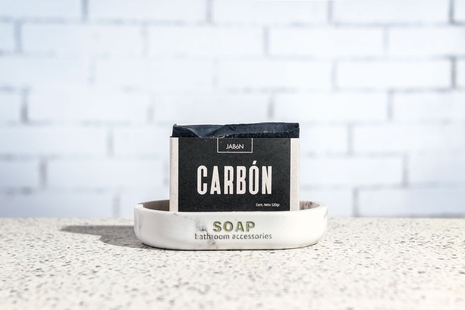 Colección de productos de cuidado de la piel y cosmética minimalista sobre una mesa de mármol iluminada de forma natural