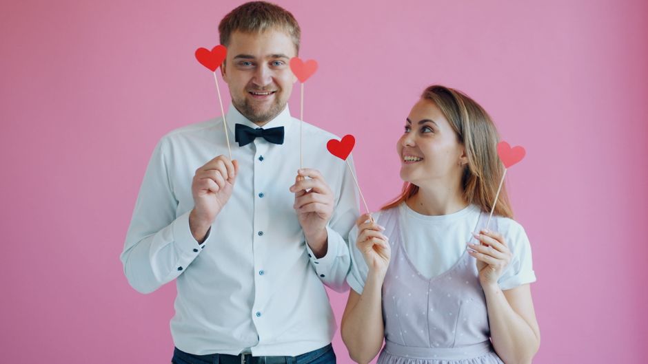 Comedic couple making funny faces while filming a prank video in a grocery store