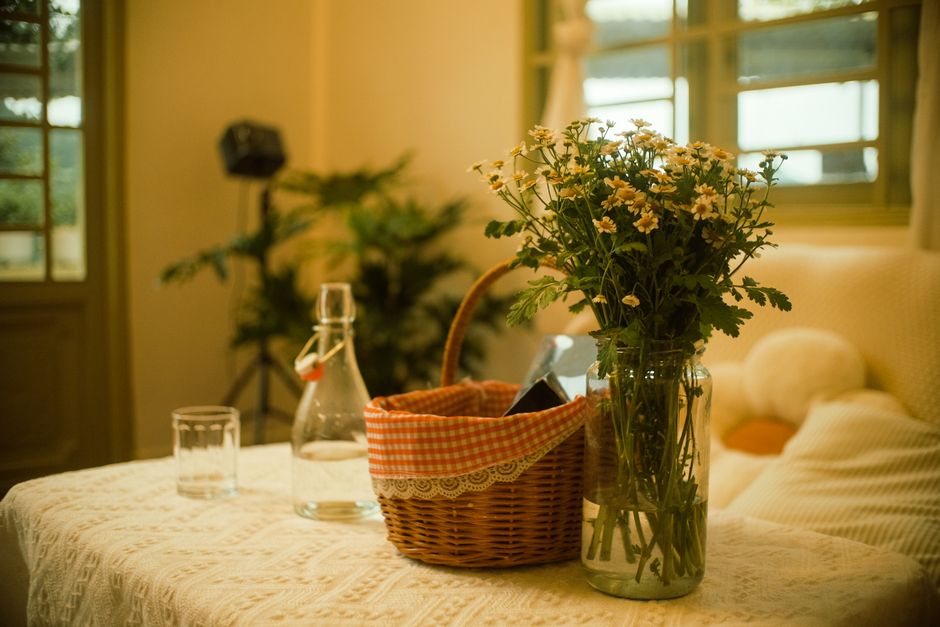 Cozy cottagecore setting with vintage teacup, dried wildflowers, and open antique book on a wooden table