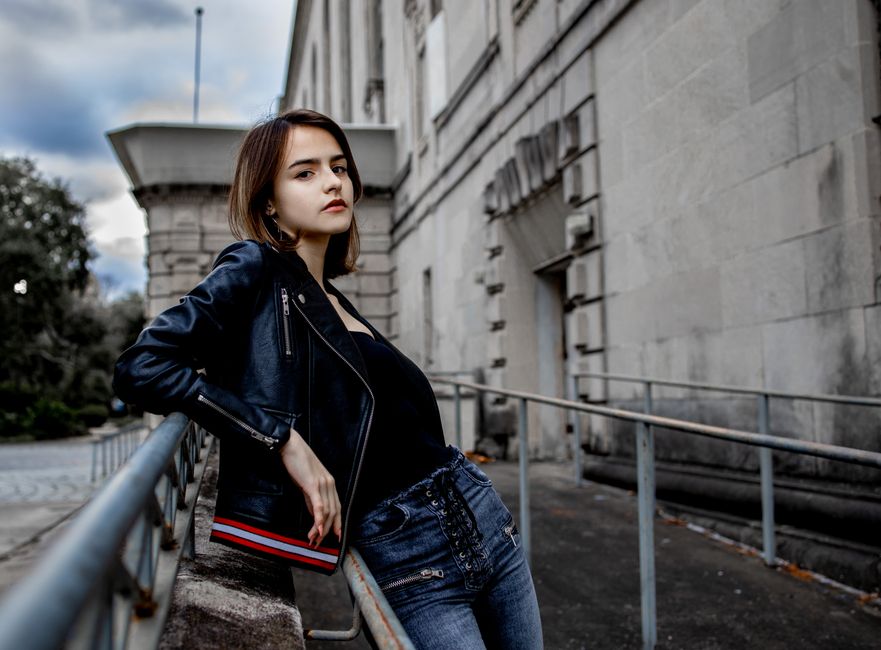 Edgy street style creator posing with flash photography against a dark urban background