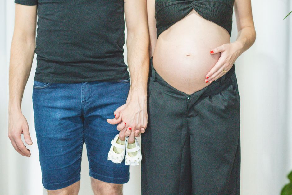 Expectant parents browsing baby name aesthetic mood boards on a smartphone