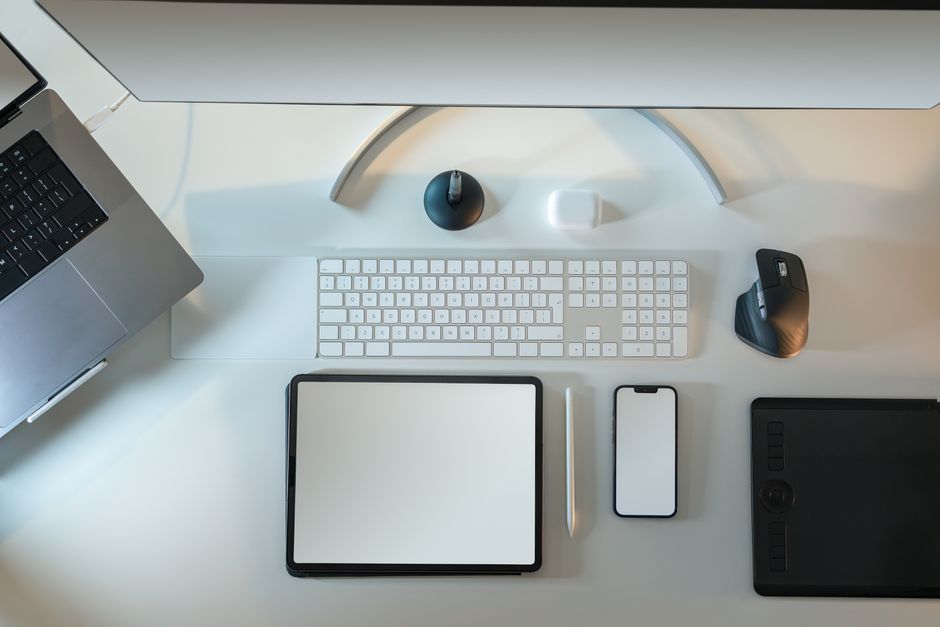 Flat-lay desk setup showing branding moodboards, tablet with social analytics, and a trademark contract