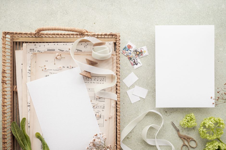 Flat-lay of vintage accessories including a brass pocket watch, leather-bound journal, and fountain pen