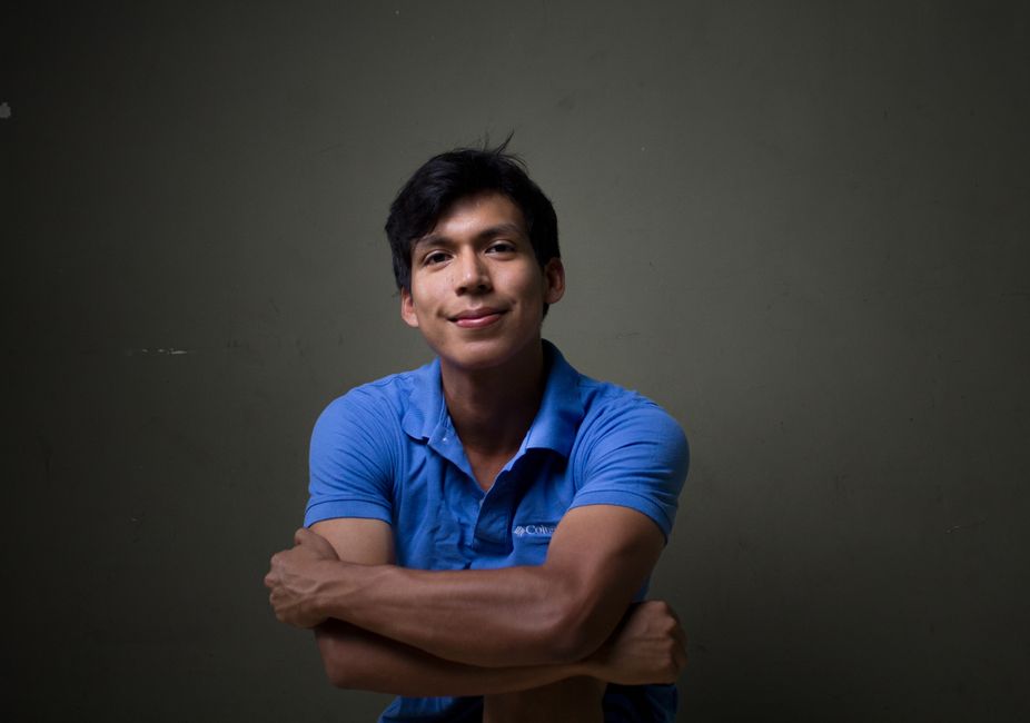Joven creador de contenido revisando opciones de nombres para tiktok para ser famoso en su teléfono móvil frente a un aro de luz