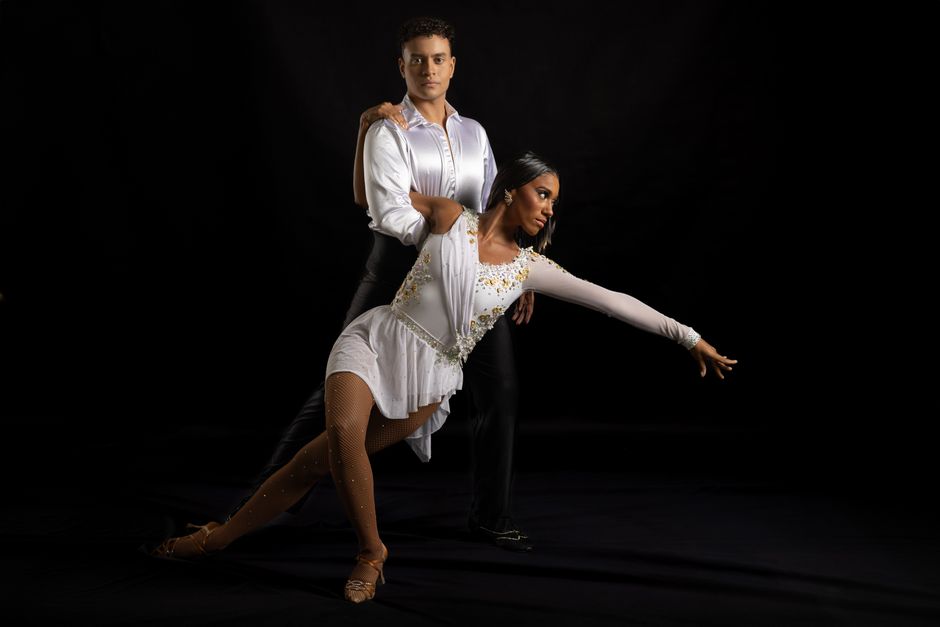 Latin dance partners performing an expressive salsa spin during a social dance event