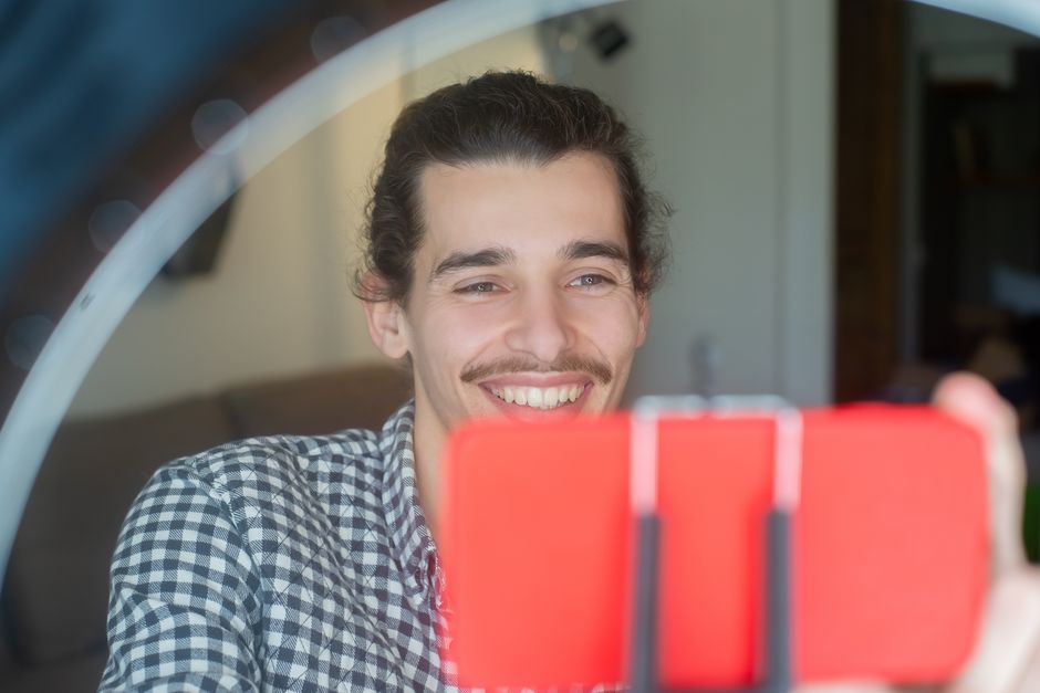 Meme creator laughing at a phone screen displaying viral TikTok comments