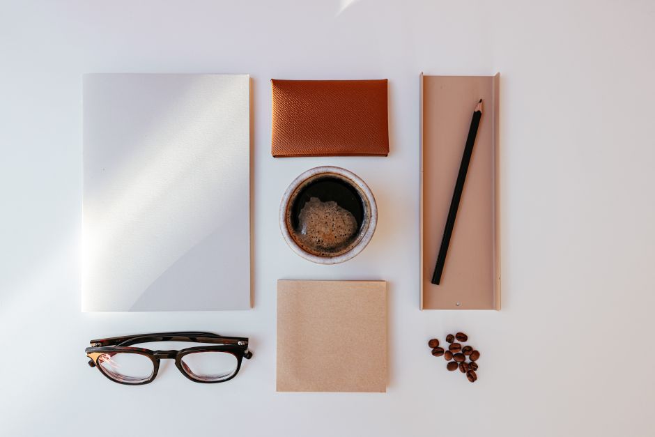 Overhead flatlay of celestial notebooks, crystals, and a tablet displaying social media profiles