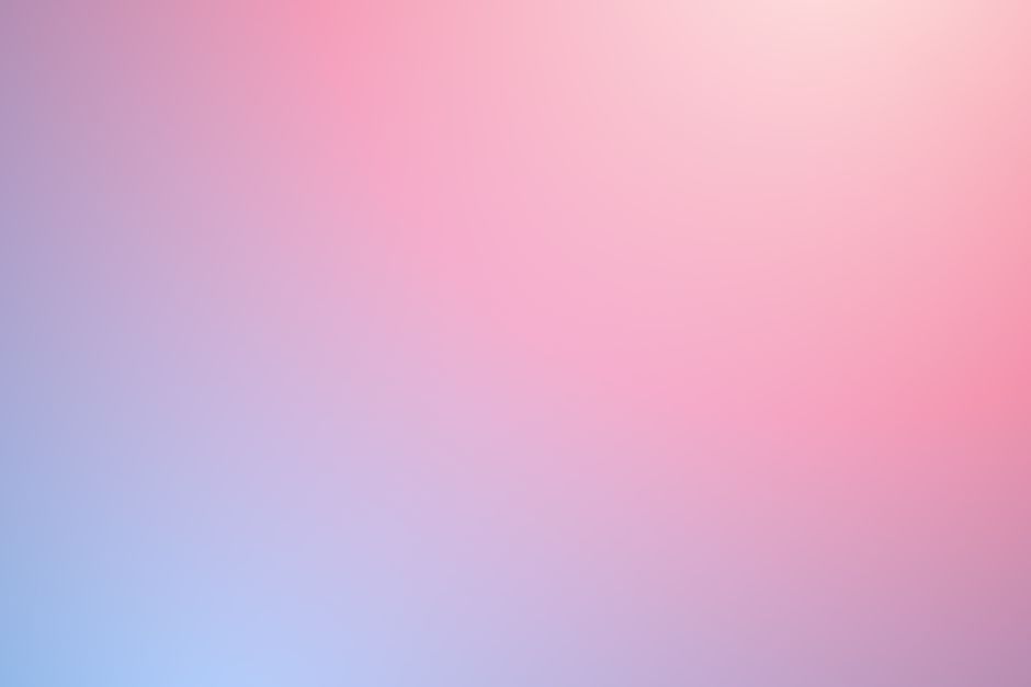 Pastel pink and peach gaming desk setup featuring cute plushies and cozy lighting
